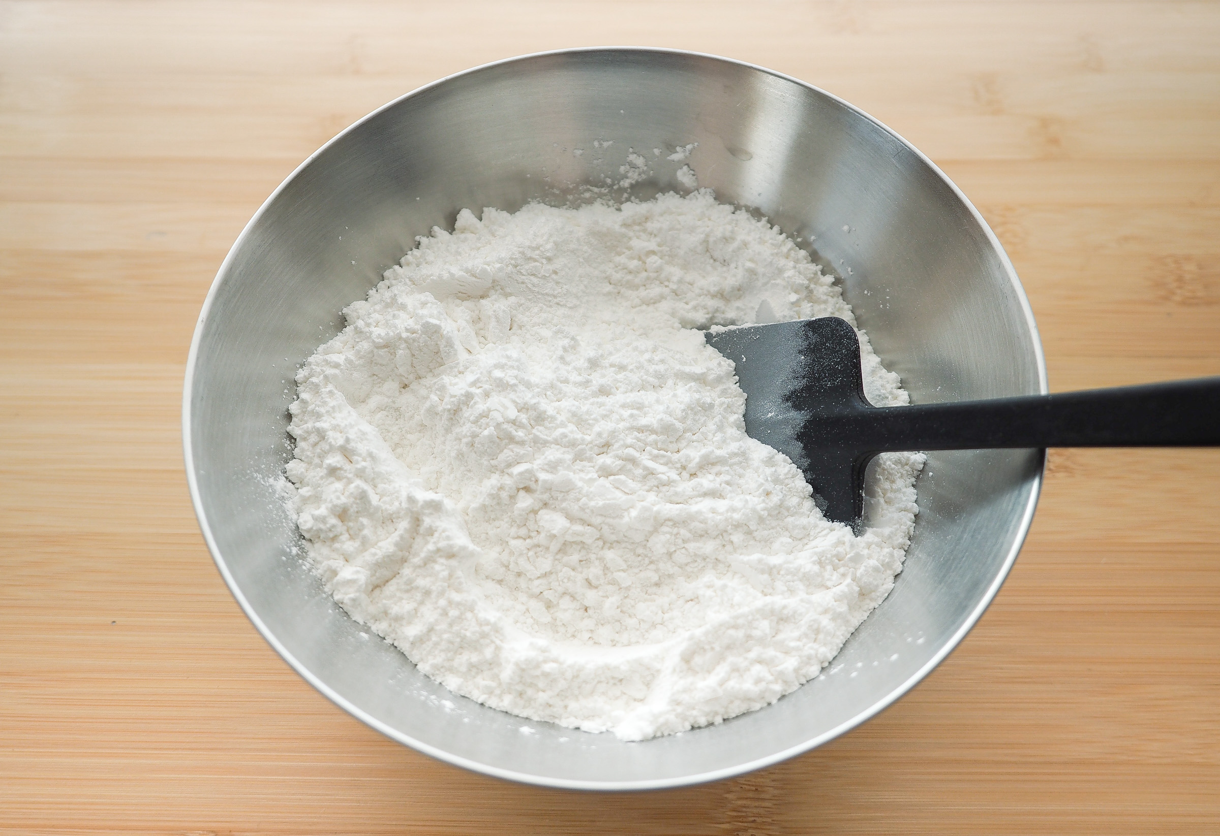 ボウルにだんご粉と砂糖を入れ、ヘラなどを使ってよく混ぜ合わせます。